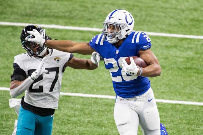 Indianapolis Colts rookie running back Jonathan Taylor stiff-arms a Jacksonville Jaguars defender during his franchise-record 253 rushing yards on Sunday.